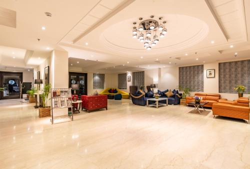 a large lobby with couches and chairs and a chandelier at Ramada by Wyndham Kasauli in Kasauli