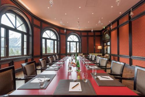 a long table in a room with windows at Hotel Schweizerhof St. Moritz in St. Moritz