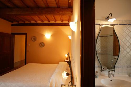 sypialnia z łóżkiem, wanną i umywalką w obiekcie Agriturismo Podere San Gregorio w mieście Pienza