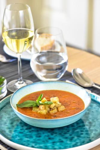 a bowl of soup on a table with a glass of wine at Central Monchique Hotel - Villa Termal Spa Resort - by Unlock Hotels in Monchique