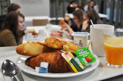 une assiette de nourriture sur une table avec du jus d'orange dans l'établissement Study Hôtel Bordeaux Lormont, à Lormont