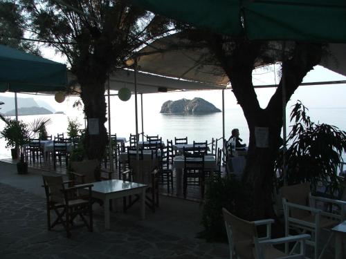 a restaurant with tables and chairs and a view of the water at Sappho Hotel in Skala Eresou