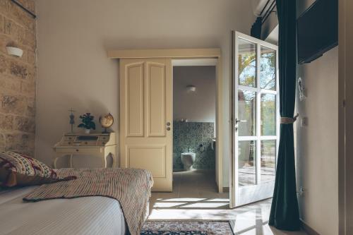 a bedroom with a bed and a door leading to a bathroom at Antica Villa Colonica in Sorso