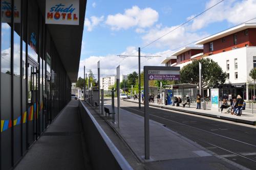 an empty city street with people walking on the sidewalk at Study Hôtel Bordeaux Lormont in Lormont