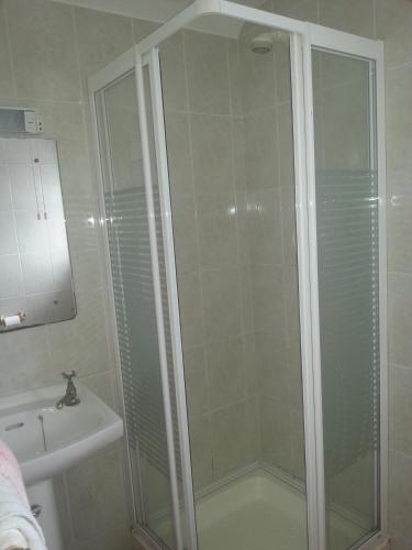 a shower with a glass door next to a sink at Aran View - Radharc Arainn B&B in Spiddal