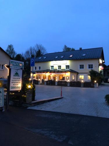 a building with a parking lot in front of it at Penzion RETRO in Petrovice