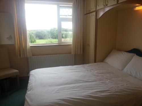 ein Schlafzimmer mit einem weißen Bett und einem Fenster in der Unterkunft Aran View - Radharc Arainn B&B in Spiddal