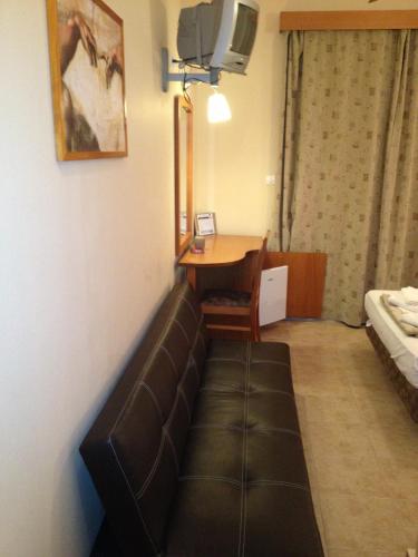 a room with a couch and a table and a desk at Sappho Hotel in Skala Eresou
