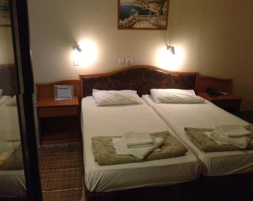 a hotel room with two beds with towels on them at Sappho Hotel in Skala Eresou