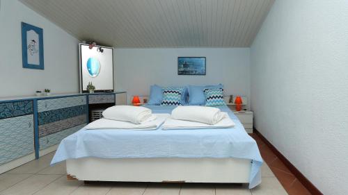 ein blau-weißes Schlafzimmer mit einem großen Bett in der Unterkunft Apartments Nina Beach in Makarska