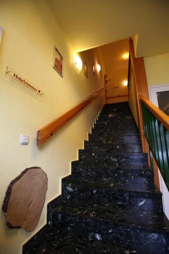 a stairway in a building with a log on the wall at Hotel garni Harzer Hof in Osterode