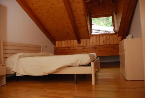 a bedroom with a bed and a window at Maso Anna in Commezzadura