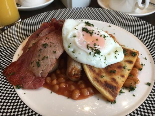a plate of breakfast food with eggs bacon beans and toast at Glenlossie Guest House in Dumfries