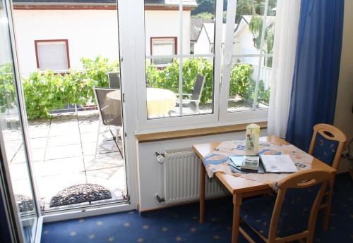 ein kleiner Tisch und Stühle in einem Zimmer mit Fenster in der Unterkunft Ferienwohnung Schneemann in Valwig