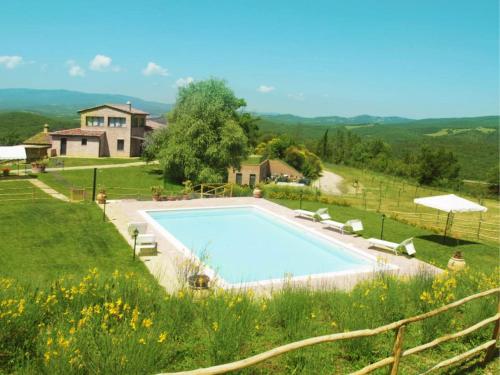 a swimming pool in a field with a house at La Fornace di San Galgano in Frosini