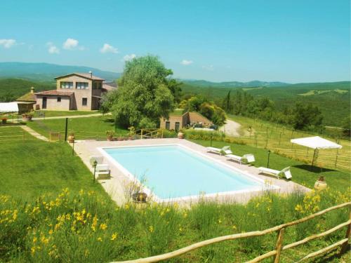 a swimming pool in a field with a house at La Fornace di San Galgano in Chiusdino