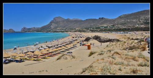 una playa con un montón de sombrillas y el océano en Elafonisi House, en Livadia