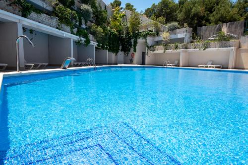 a large blue swimming pool in a building at Alicante Hills Luxury Beach Apartment in Alicante