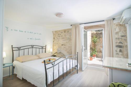 um quarto com uma cama e uma porta de vidro deslizante em Guest house Mendi em Trogir