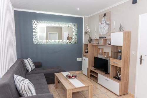 a living room with a couch and a television at Nina Apartment in Chania