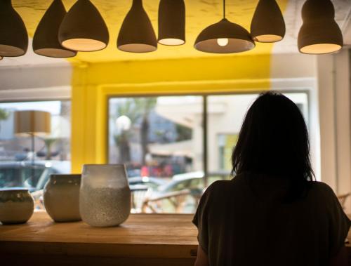 a woman sitting at a counter with vases on it at Hostal Blanca in Can Picafort