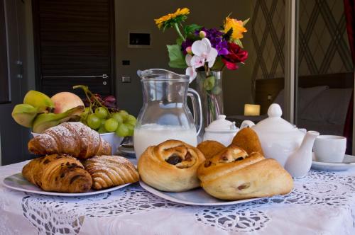 a table with plates of bread and pastries on it at B&B Albachiara in San Leone