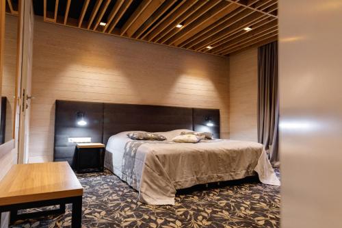 a bedroom with a bed and a wooden wall at Voevodyno Resort in Tur'ya Pasika