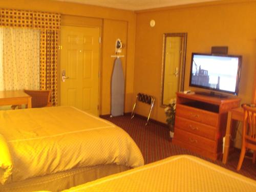 a hotel room with a bed and a flat screen tv at Virginia Inn in Lawrence