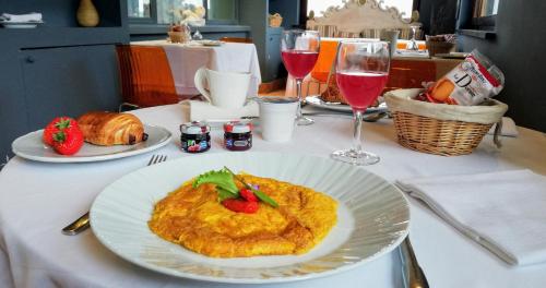 un tavolo con un piatto di cibo e due bicchieri di vino di Hotel & Ristorante degli Angeli a Magliano Sabina