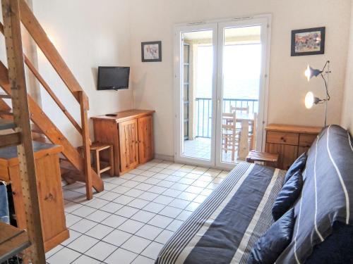 a bedroom with a bed and a television and a balcony at Apartment Les Roches Bleues-2 by Interhome in Collioure