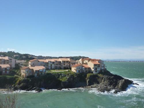 un groupe de maisons sur une île rocheuse dans l'océan dans l'établissement Apartment Les Roches Bleues-2 by Interhome, à Collioure