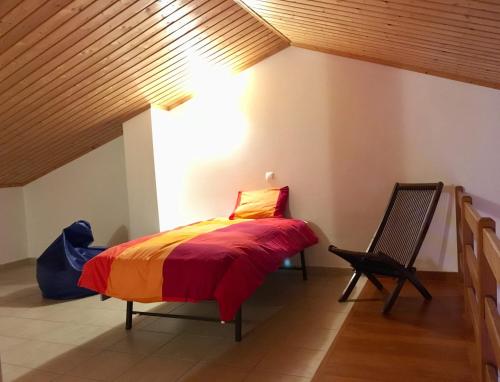 een slaapkamer met een bed en een stoel bij Casa Trinta - Praia da Arrifana in Praia da Arrifana