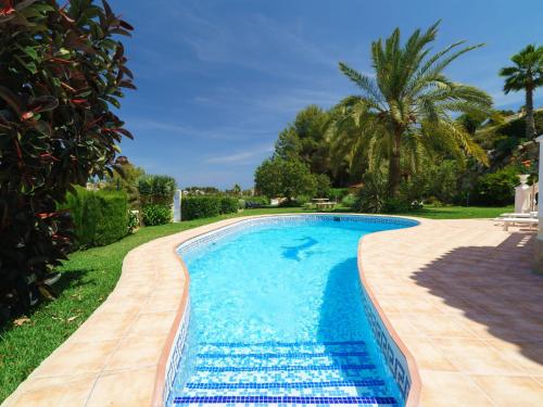 a swimming pool in a yard with a palm tree at Holiday Home Montemar by Interhome in Fanadix