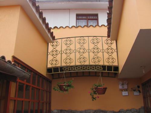 a balcony with potted plants on the side of a building at Kuska Hostal in Cusco