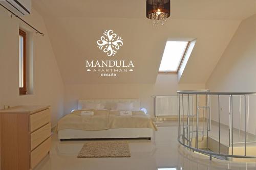 a bedroom with a bed and a sign on the wall at Mandula Apartman in Cegléd