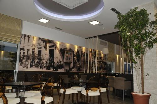 une salle à manger avec des tables, des chaises et un mur dans l'établissement Hotel Malta, à Mostar