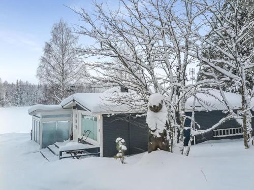 una casa cubierta de nieve junto a un árbol en Holiday Home Einola by Interhome en Laiska