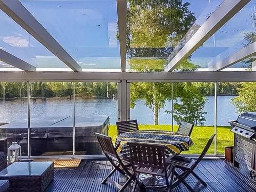 una veranda protetta con tavolo, sedie e una barca di Holiday Home Einola by Interhome a Laiska