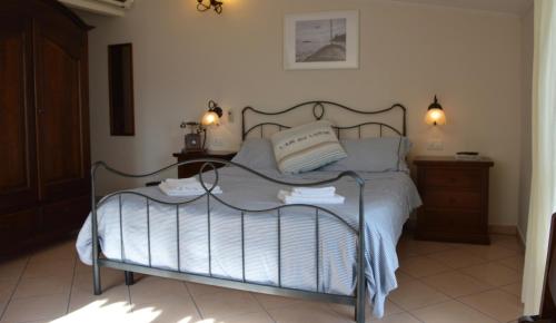 een slaapkamer met een bed met een metalen frame bij Albergo Tirreno in Marina di Camerota