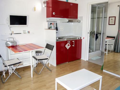 Il comprend une cuisine équipée d'un réfrigérateur rouge, d'une table et de chaises. dans l'établissement Studio le Clos des Lavandes-1 by Interhome, à Bandol