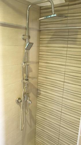 a shower with a shower head in a bathroom at Maro Rooms in Chania