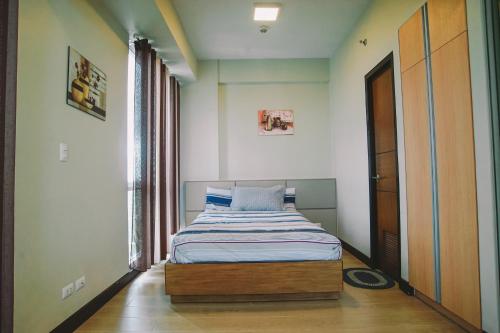 a small bedroom with a bed in a room at Mactan Newtown Beach Condo in Mactan