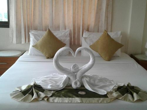 two swans making a heart shape on a bed at Seaview Sriracha Hotel in Si Racha