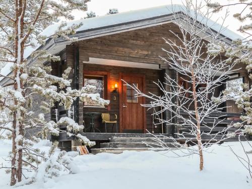 a log cabin with a wooden door in the snow at Holiday Home Lemmenliekki 3 by Interhome in Lemmenjoki