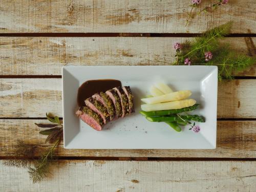 a plate of food with meat and vegetables on a table at Landgasthof Bären in Madiswil