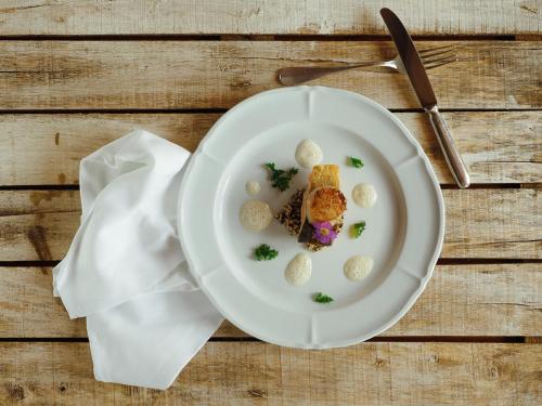 a white plate with food on a wooden table at Landgasthof Bären in Madiswil