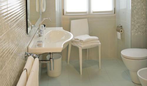 a white bathroom with a sink and a toilet at Residence Villa Maurice in Stresa