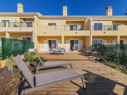 a building with a patio with benches in front of it at Holiday Home Vila Caravela by Interhome in Estevais