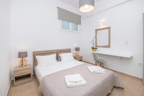 Un dormitorio blanco con una cama con dos toallas encima. en Agia Anna Apartments, en Parikia