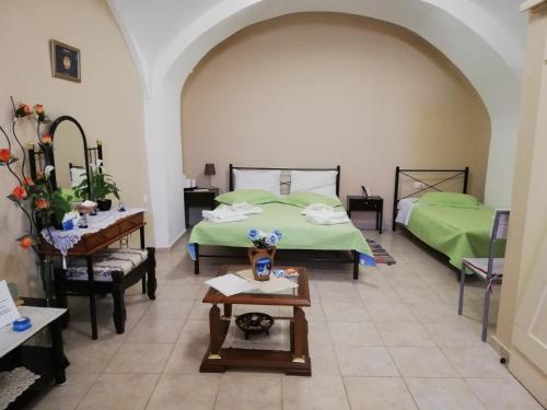 a bedroom with two beds and a table with flowers on it at Mantilaria in Fira